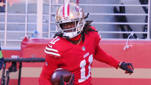 49ers wide receiver Brandon Aiyuk runs with a ball.